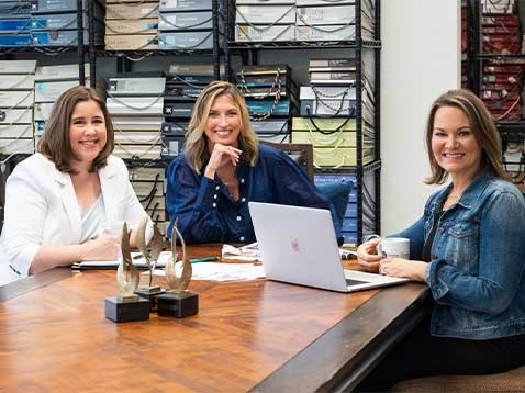 Three smiling women sitting around a table